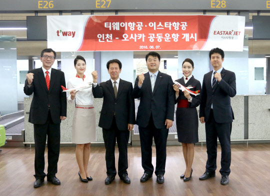 티웨이항공과 이스타항공은 인천-오사카 노선의 공동운항을 시작한다고 7일 밝혔다. 최수영 티웨이항공 영업담당이사(왼쪽 세 번째), 최종태 이스타항공 영업서비스본부장(네 번째) 등 임직원들이 공동운항 개시 첫 탑승편을 축하하며 기념 촬영을 하고 있다. <이스타항공 제공>